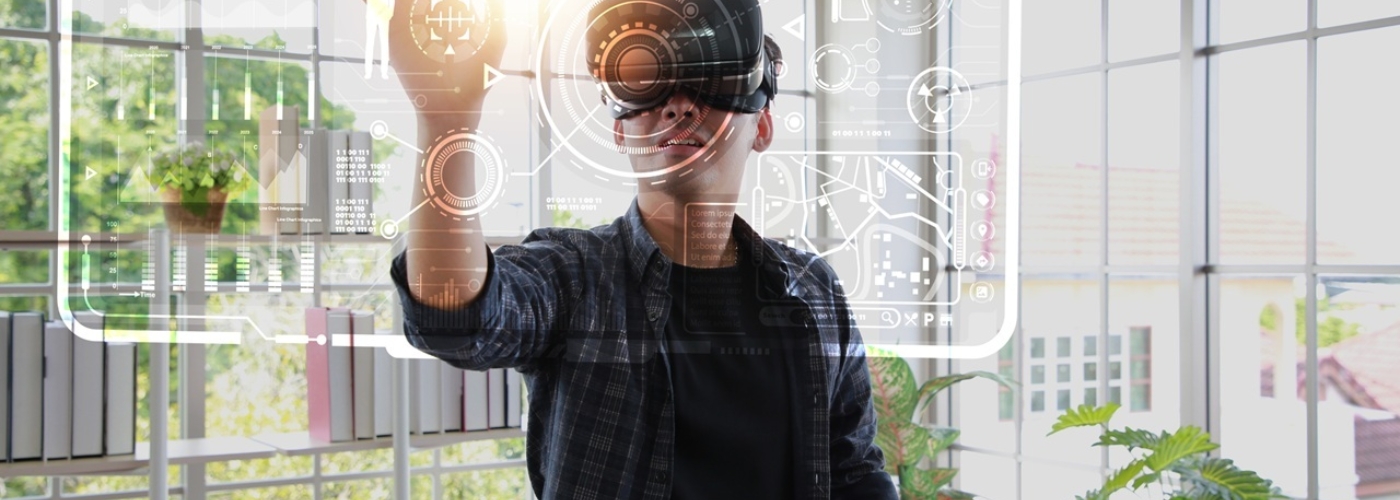 Ein Mann mit einer Virtual-Reality-Brille tippt mit dem Finger auf eine virtuelle Grafik in der Luft.