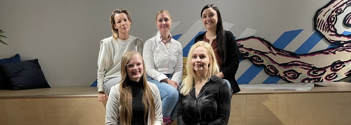 Fünf Frauen sitzen auf einer Holztreppe.
