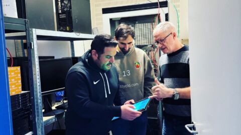 Drei Männer schauen auf ein Tablet