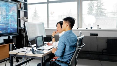 Zwei Männer sitzen vor einem PC