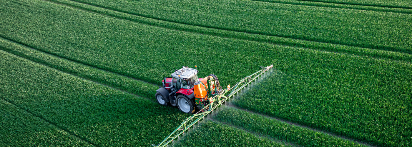 Traktor mit Feldspritze auf einem Acker