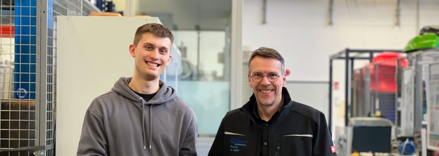 Zwei Männer halten einen Pedelec-Motor und zwei 3D-gedruckte Zahnräder in der Hand