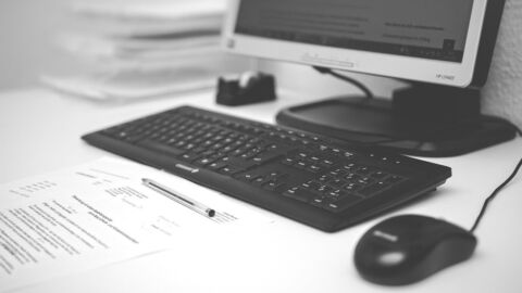 Ein Monitor, eine Tastatur und eine Maus auf einem weißen Tisch