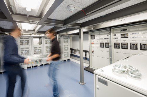 Zwei Männer stehen in einem Technikraum