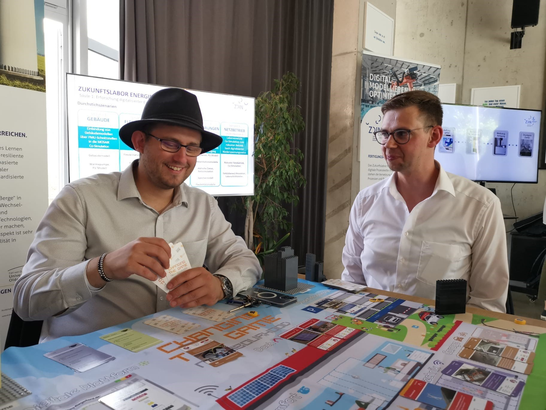 Zwei Männer sitzen an einem Tisch und spielen ein Spiel
