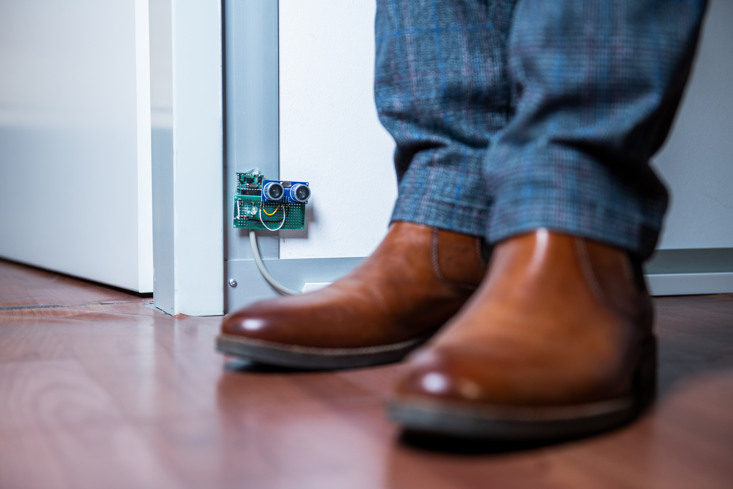 Braune Lederschuhe und ein technischer Gegenstand an der Wand im Hintergrund