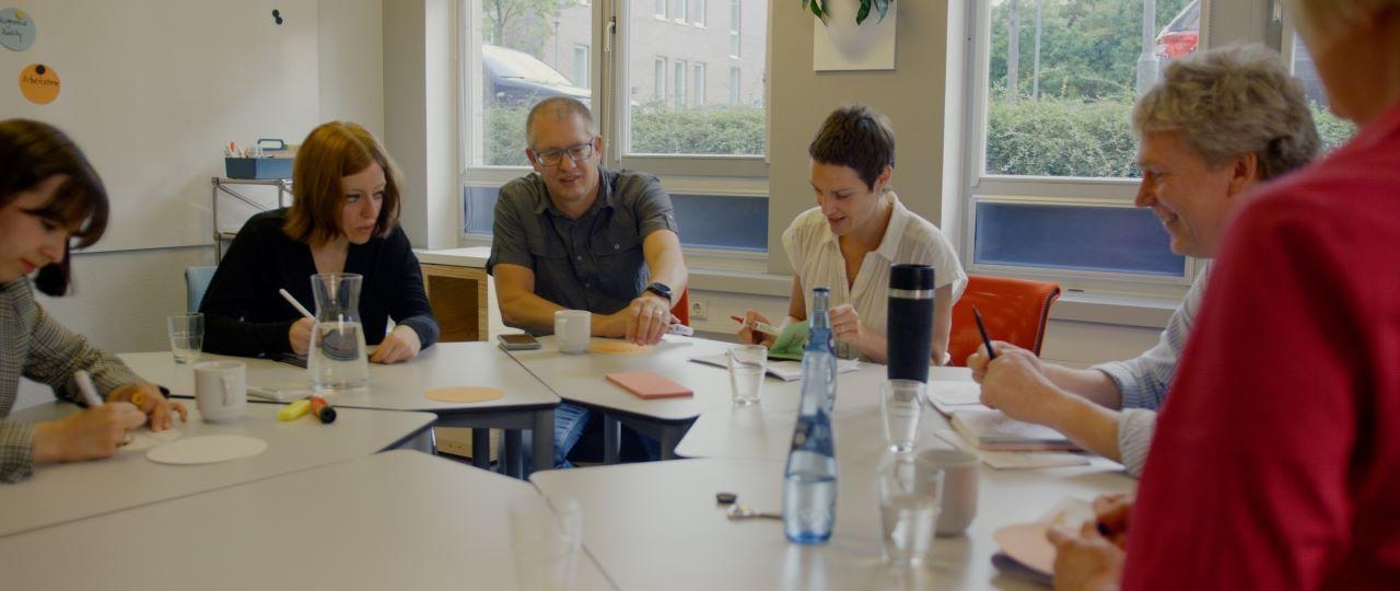 Gruppe von Menschen sitzt an einem Tisch