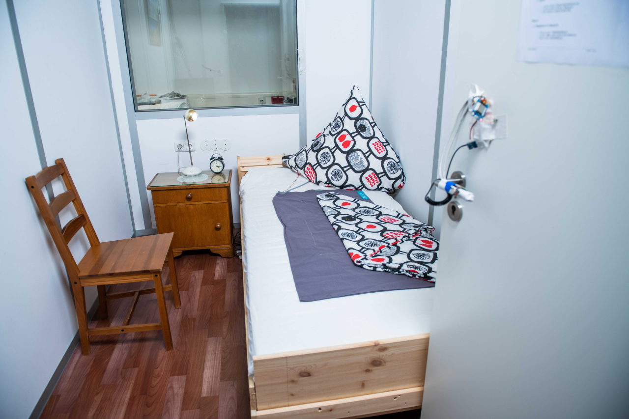 Zimmer mit Bett, Stuhl und Nachttisch