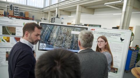 Personen stehen vor einem Infotafel