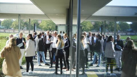 Eine Gruppe von Personen steht vor einem Gebäude