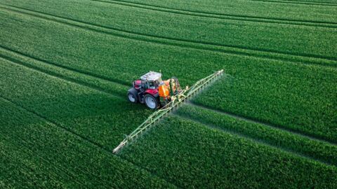 Traktor mit Feldspritze auf einem Acker