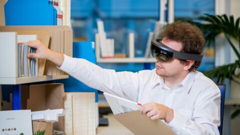 Mann mit AR-Brille sitzt an Schreibtisch