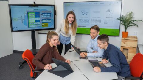 Gruppe von Menschen arbeitet zusammen an einem Tisch