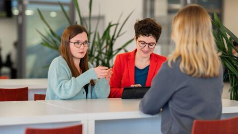 Drei Frauen sitzen an einem Tisch