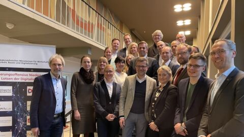 Eine Personengruppe steht auf einer Treppe und blickt in die Kamera