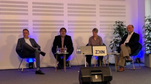 Vier Personen sitzen nebeneinander in einer Diskussion