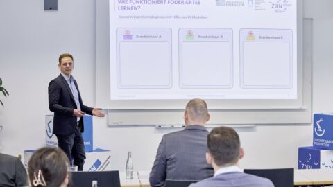 Man steht vor Leinwand und präsentiert