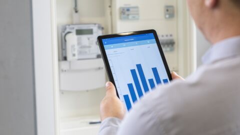 Person hält einTablet, das ein Balkendiagramm zeigt.