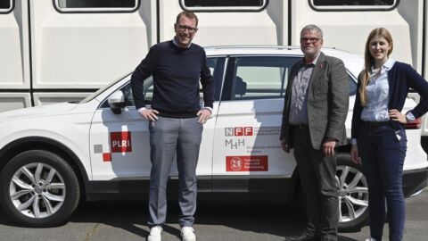 Drei Personen stehen vor einem Forschungsauto