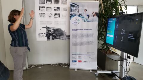 Eine Frau folgt Bewegungsanweisungen auf einem Monitor