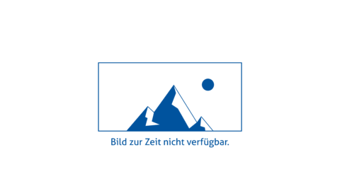 Person trägt Tablet und steht vor einer Maschine