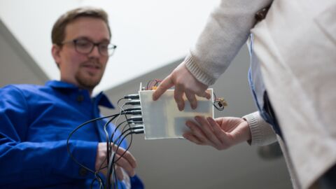 Zwei Personen blicken auf einen technischen Gegenstand
