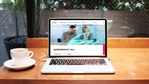 Offener Laptop auf Tisch, der den Jahresbericht 2023 zeigt