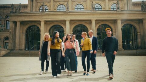 Eine Personengruppe läuft vor einem Gebäude