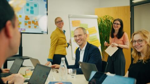 Personen in einem Besprechungsraum lachen