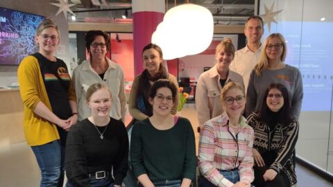 Eine Gruppe von Personen (primär Frauen) blickt in die Kamera