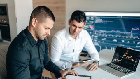 Zwei Männer werten Daten aus.