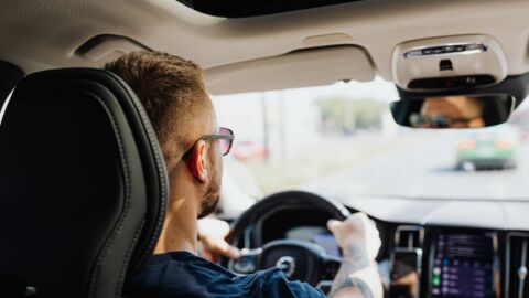 Person sitzt im Auto hinter dem Steuer