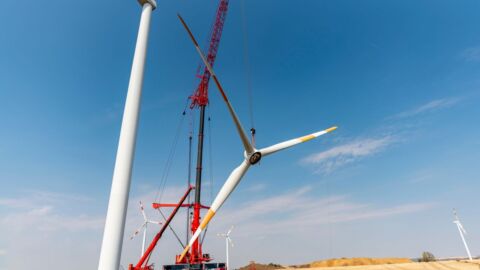 Windkraftwerk während der Bauphase mit Kran im Hintergrund