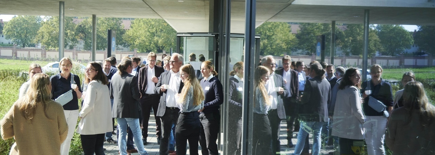 Mehrere Personen stehen vor einem Gebäude