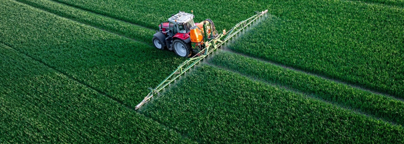 Traktor mit Feldspritze auf einem Acker