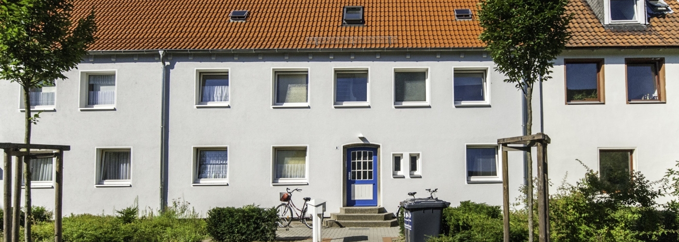 Weißes Reihenhaus mit Orangem Dach