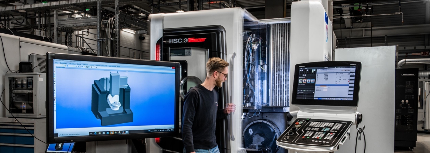 Mann steht vor Maschine