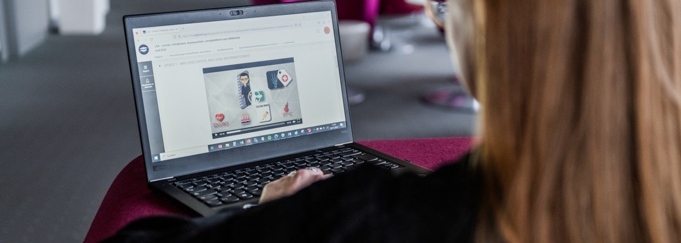 Frau blickt auf einen Laptop Bildschirm