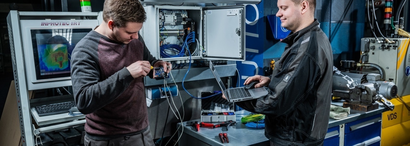 Zwei Männer arbeiten in einer Werkstatt mit Elektronik