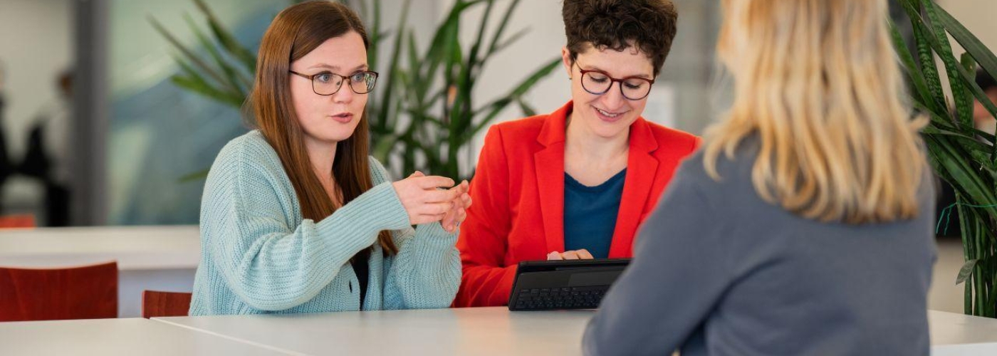 Drei Frauen sitzen an einem Tisch