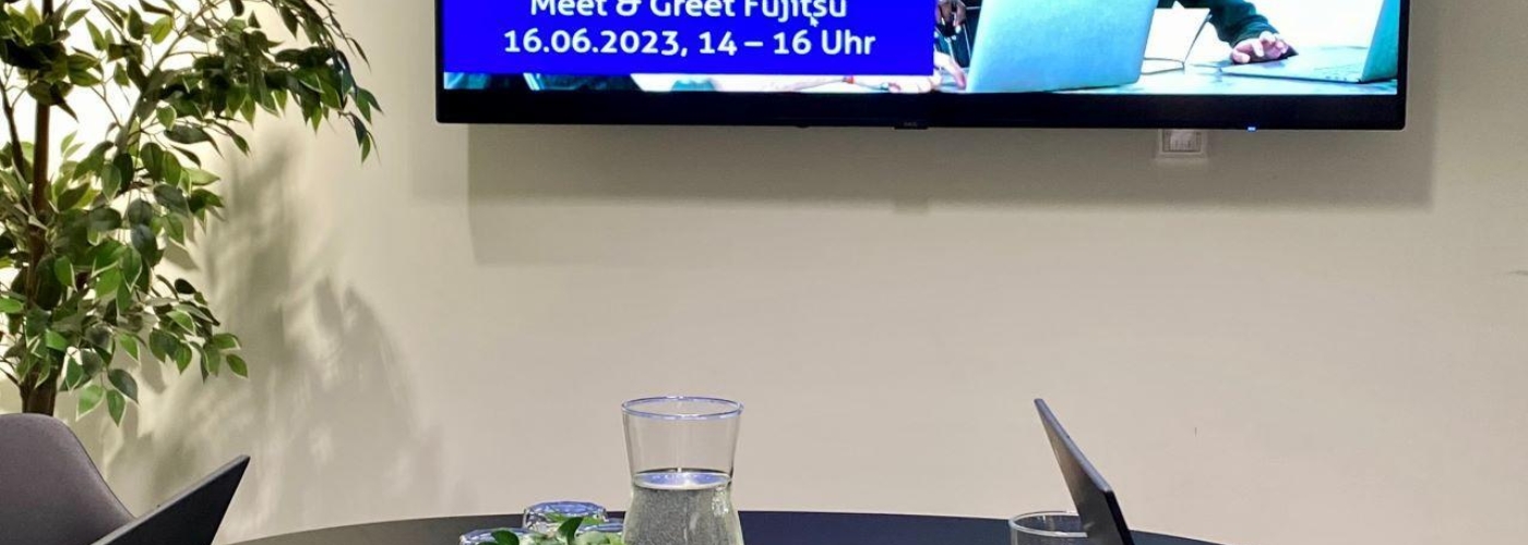 Ein Konferenzraum mit einem Fernseher an der Wand