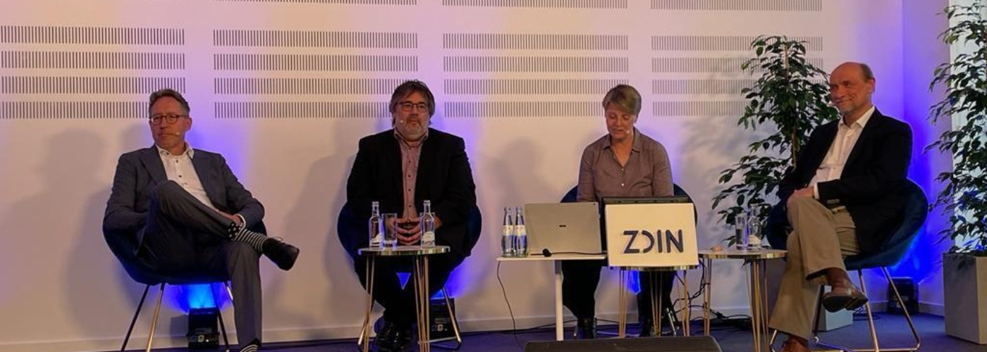 Vier Personen sitzen nebeneinander in einer Diskussion