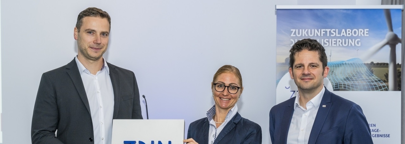 Drei Personen stehen nebeneinander