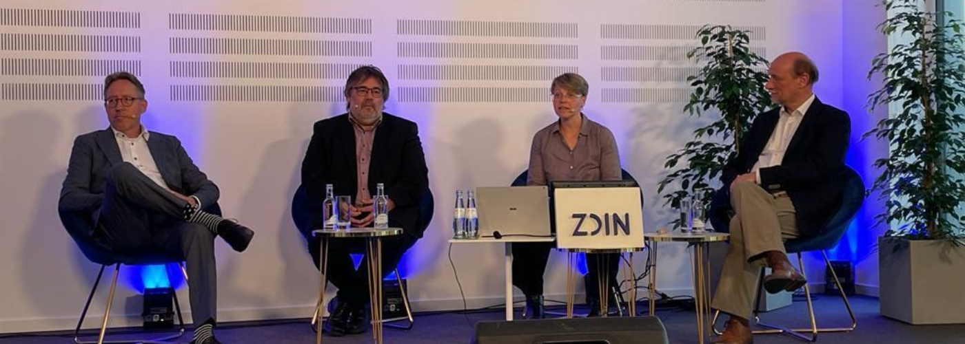 Vier Personen sitzen auf Stühlen nebeneinander