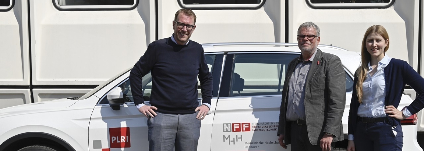 Drei Personen stehen vor einem Forschungsauto