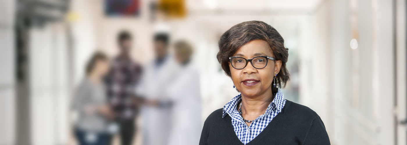 Frau mit Tablet in der Hand blickt in die Kamera