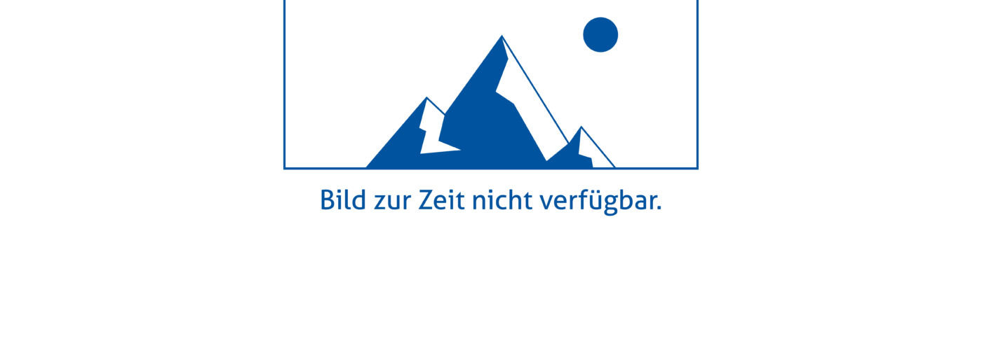 Ein Mann im blauen Hemd sitzt an einem Tisch, auf dem eine 3D-Visualisierung einer Fahrzeugkarosserie zu sehen ist.