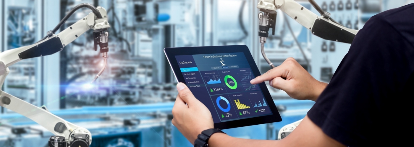 Person benutzt Tablet vor einer Maschine