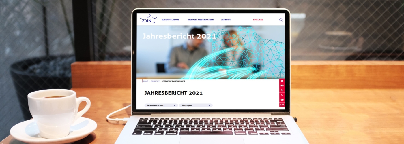 Offener Laptop auf Tisch, der den Jahresbericht 2023 zeigt