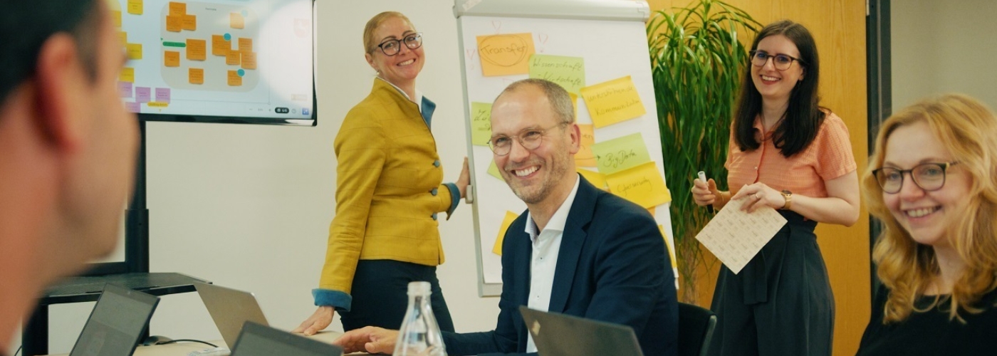 Personen in einem Besprechungsraum lachen